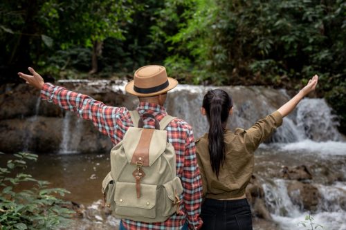 Men, women, tourists are happy and refreshed at the waterfall.
